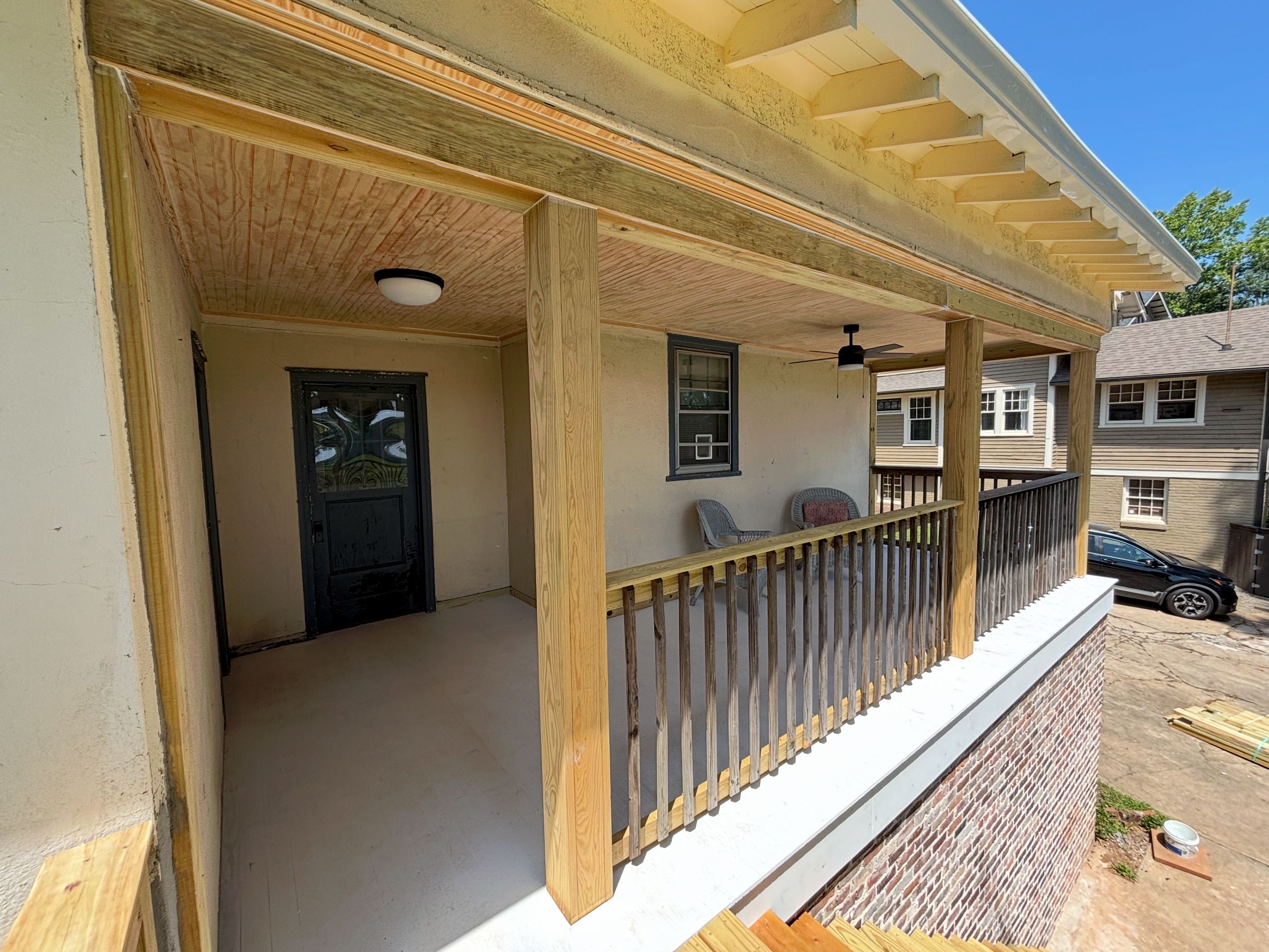 Newly installed header wrap, post columns, rafter tails, and railing tie together back porch